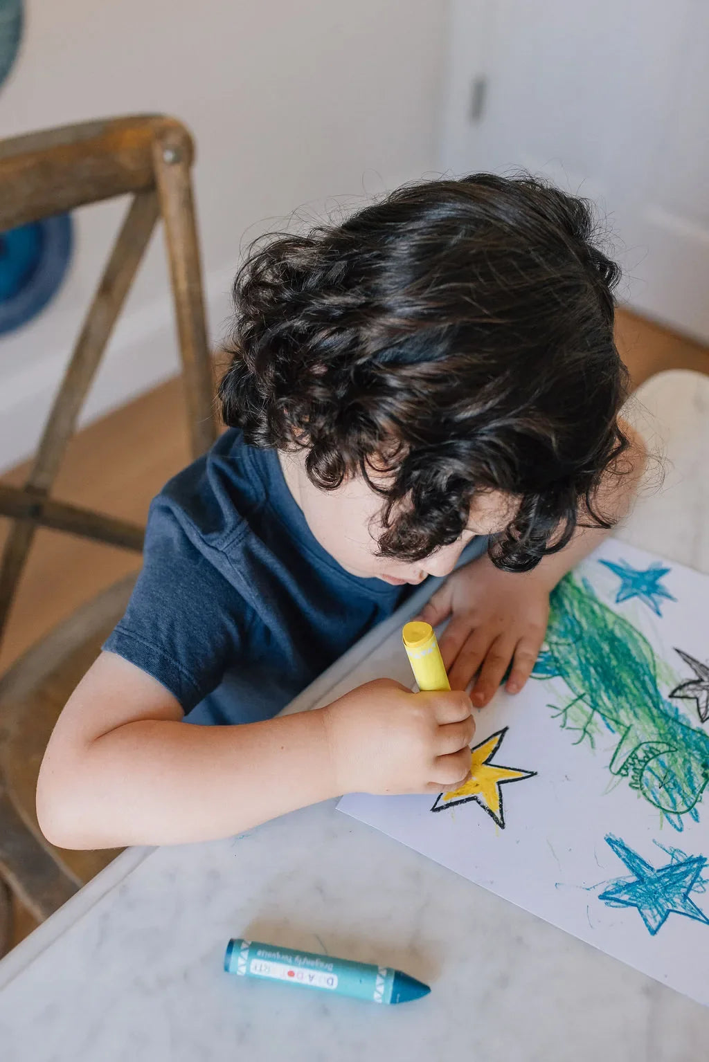 Boy coloring stars with a Jumbo Triangle Beeswax Crayon