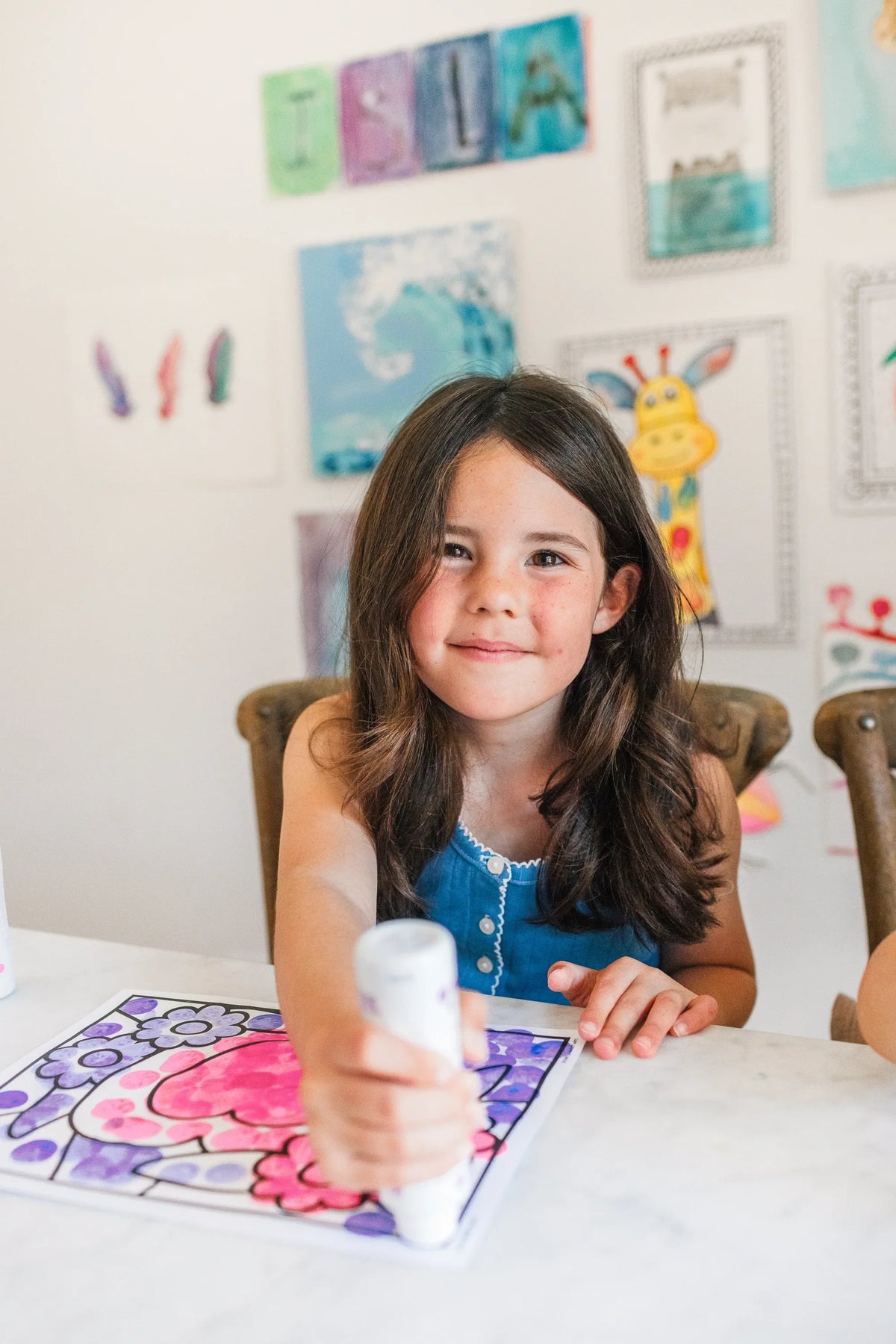 Smiling girl dotting a page from a Creative Activity Book