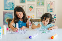 Two kids dotting activity pages side by side