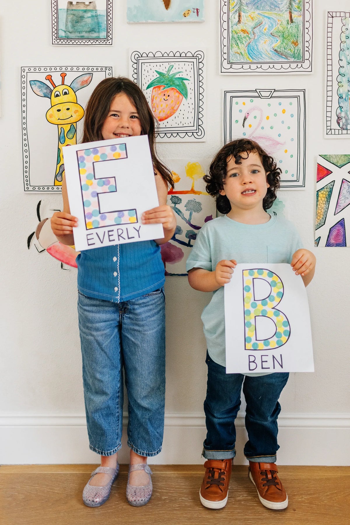 Two kids proudly showing their dotted letters
