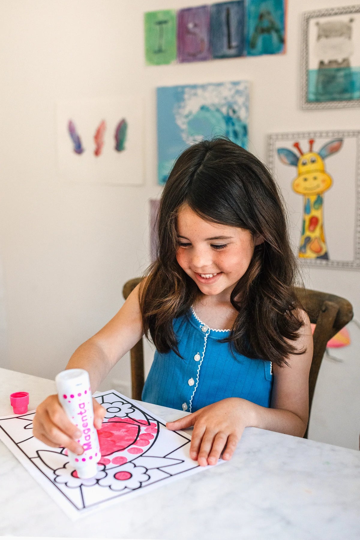 Smiling girl dotting a flower page with a Dot Marker