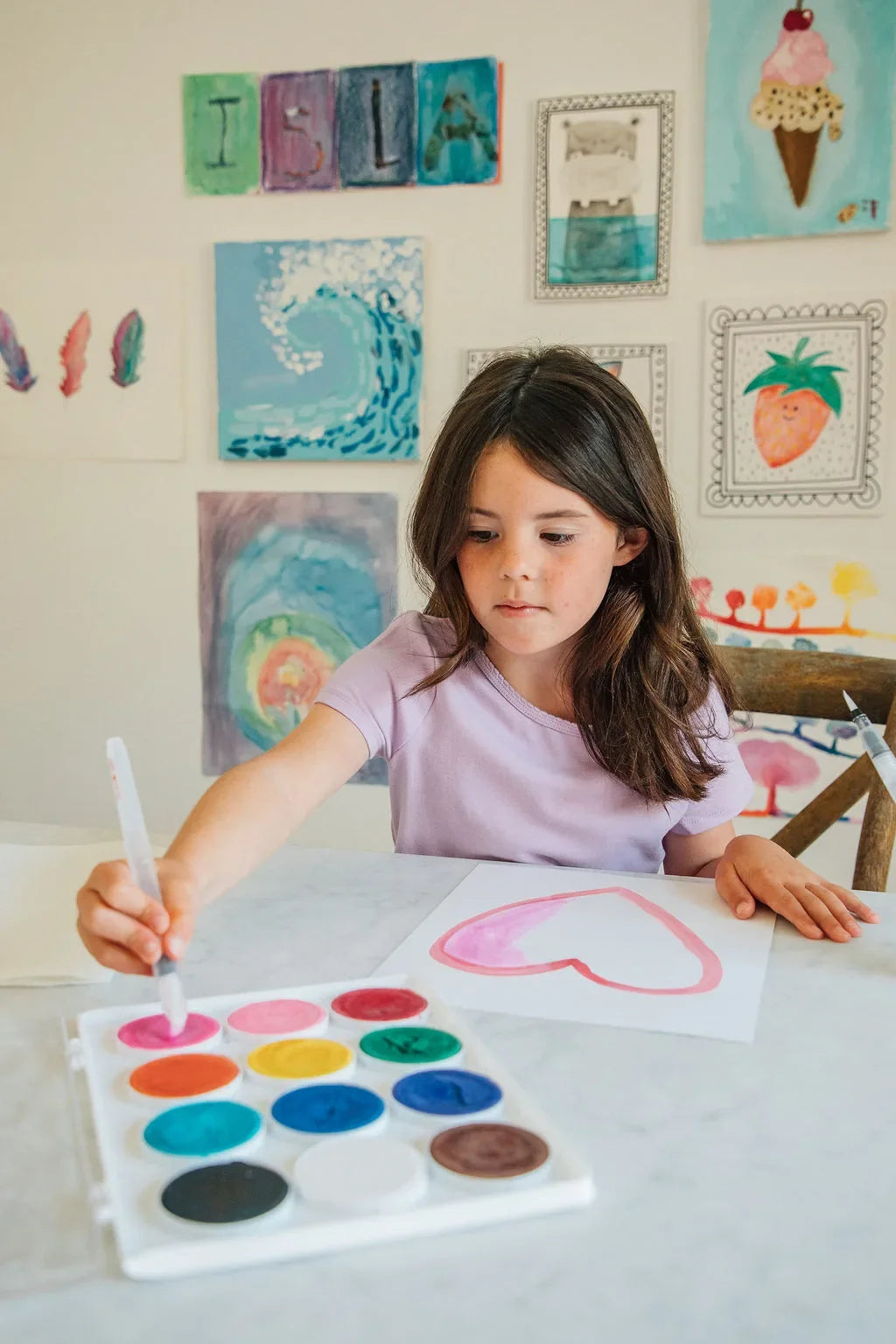 Girl painting a heart with a Swishies brush and Whirl of Color paints